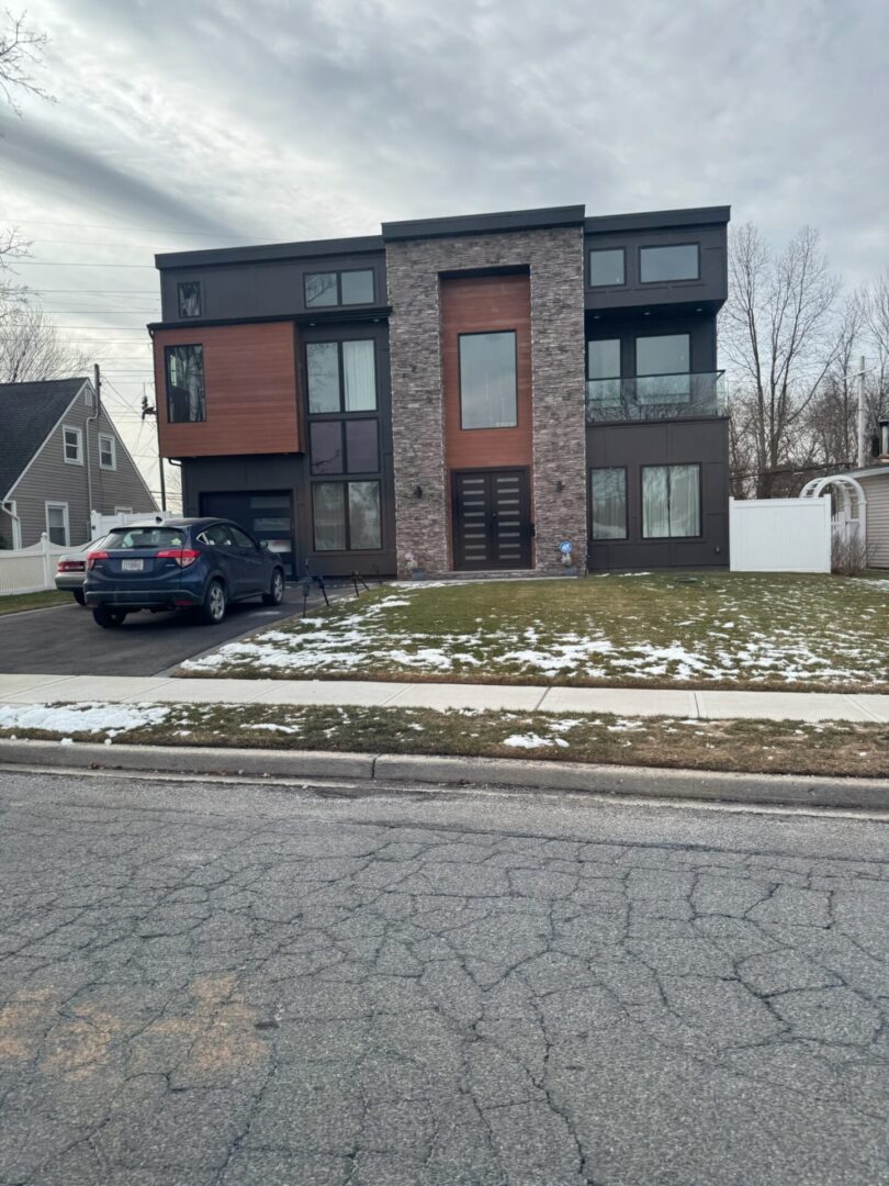 Modern two-story house with a mix of brick and wood exterior.