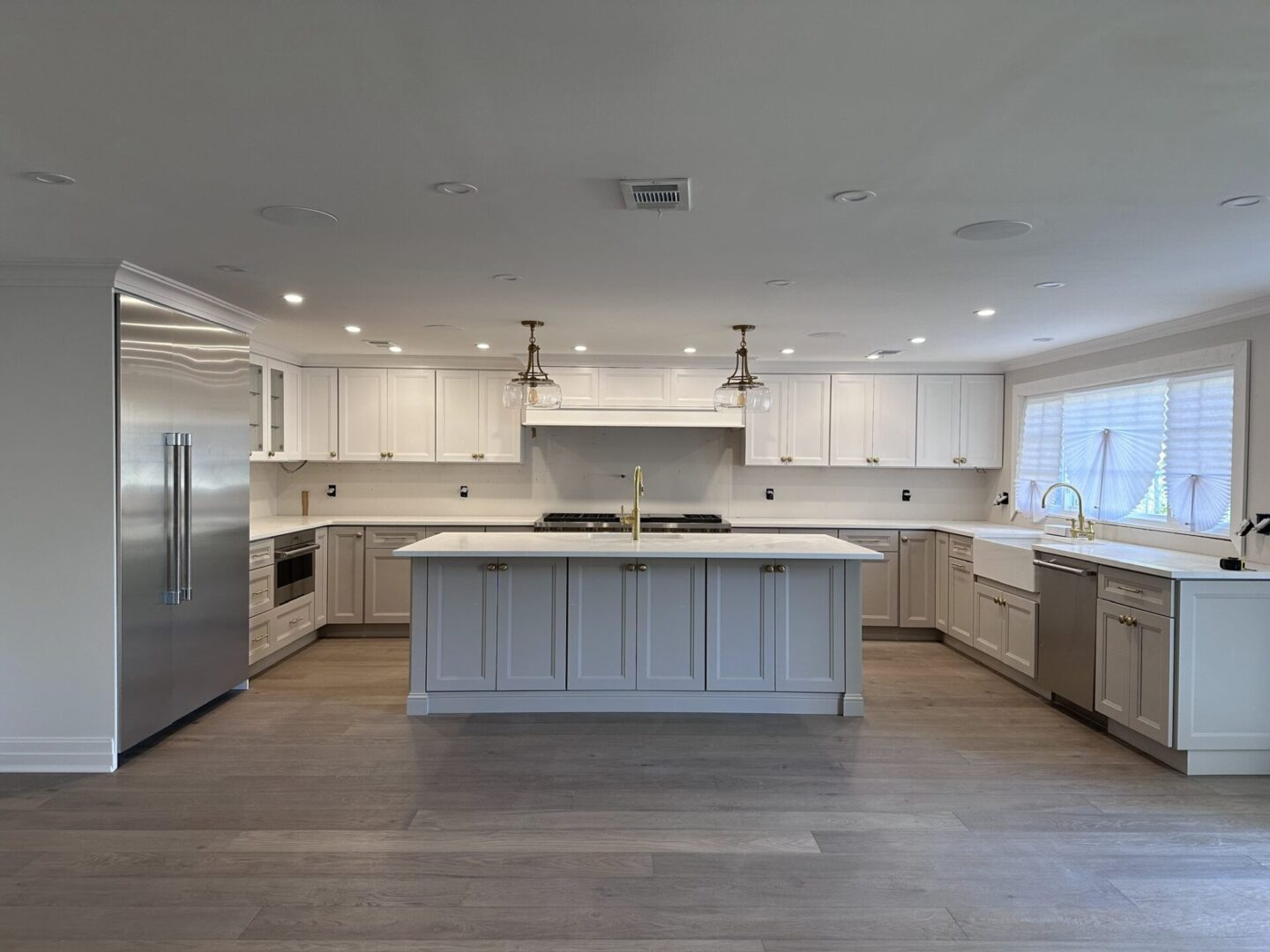 Spacious modern kitchen with white cabinets and large island.