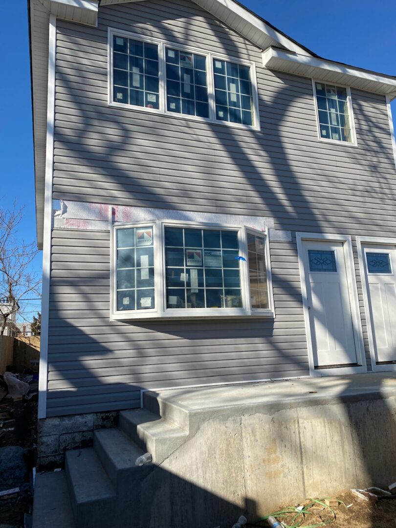 Residential house exterior with a window and door on a sunny day.