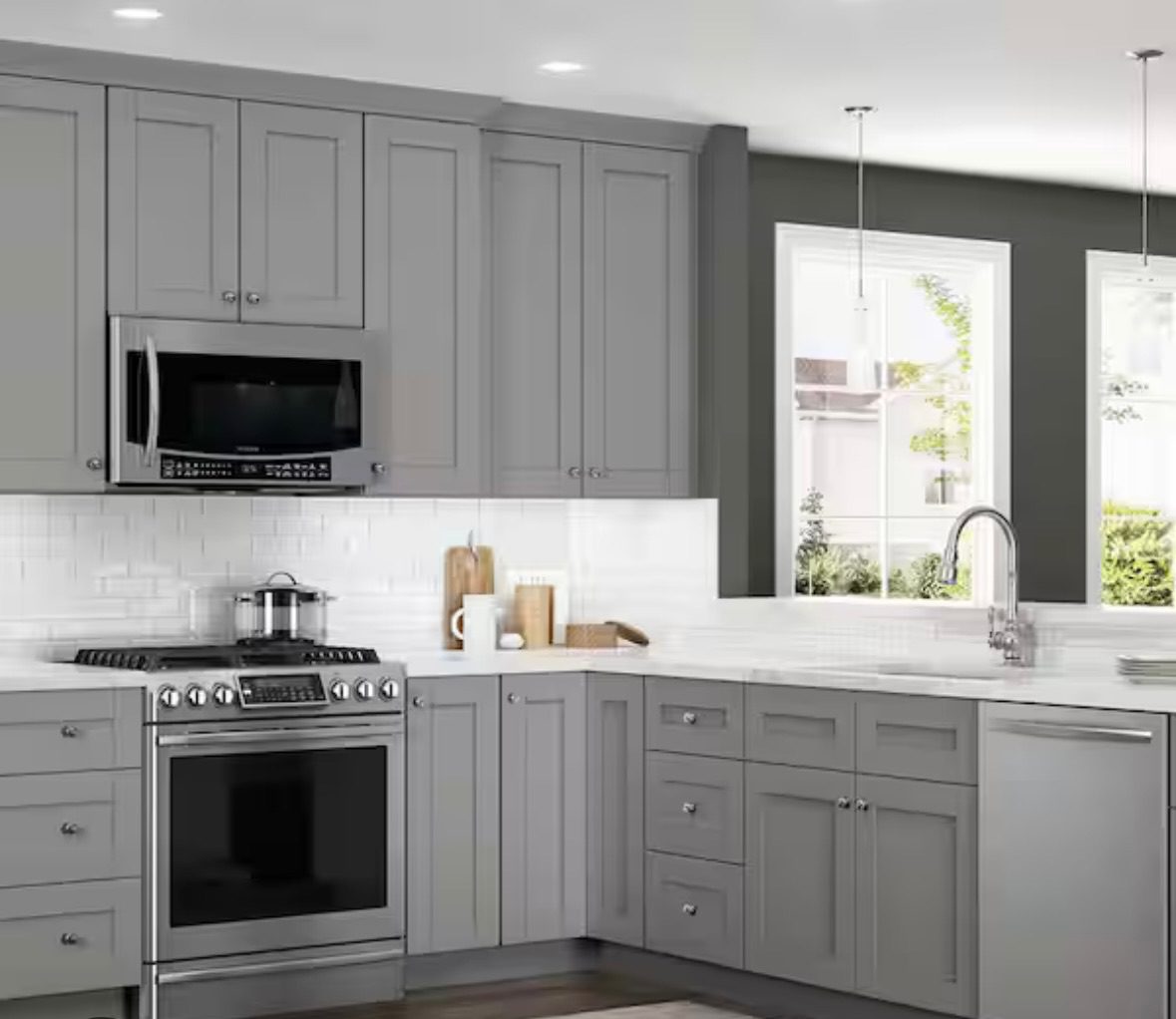 Modern kitchen with gray cabinets and stainless steel appliances.