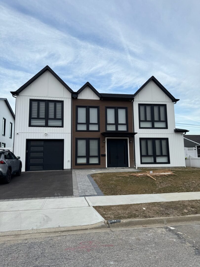 Modern two-story duplex with black and white exterior and garages.