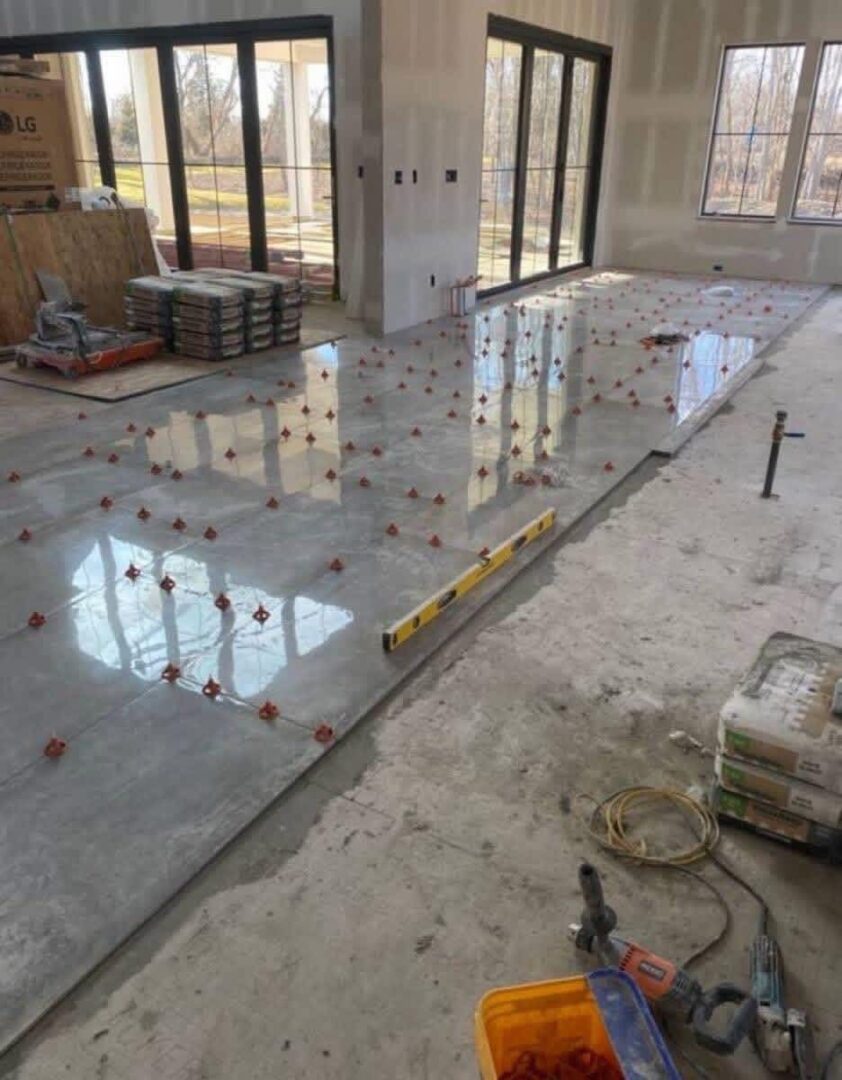 Polished concrete floor with embedded decorative elements in a construction site.