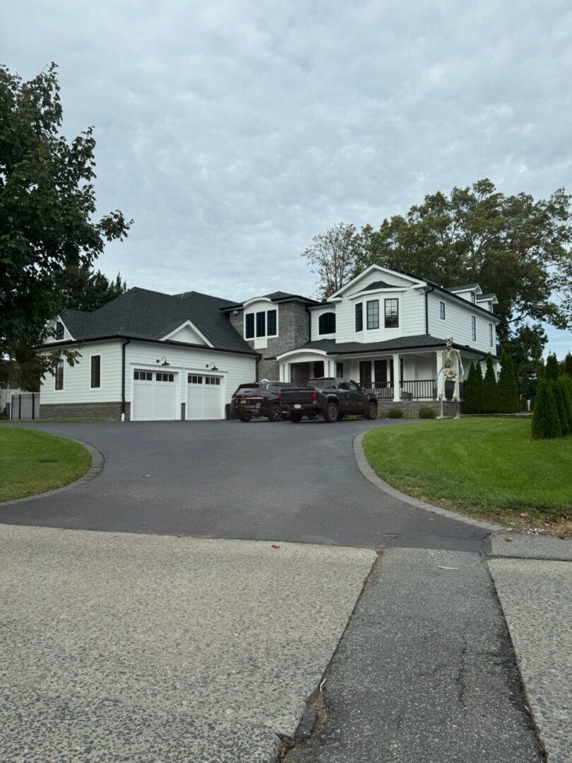 Large two-story house with a three-car garage and a spacious driveway.