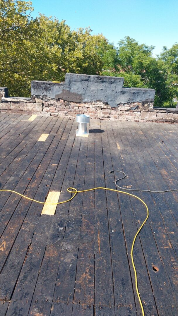 A wooden roof under repair with tools and materials scattered.