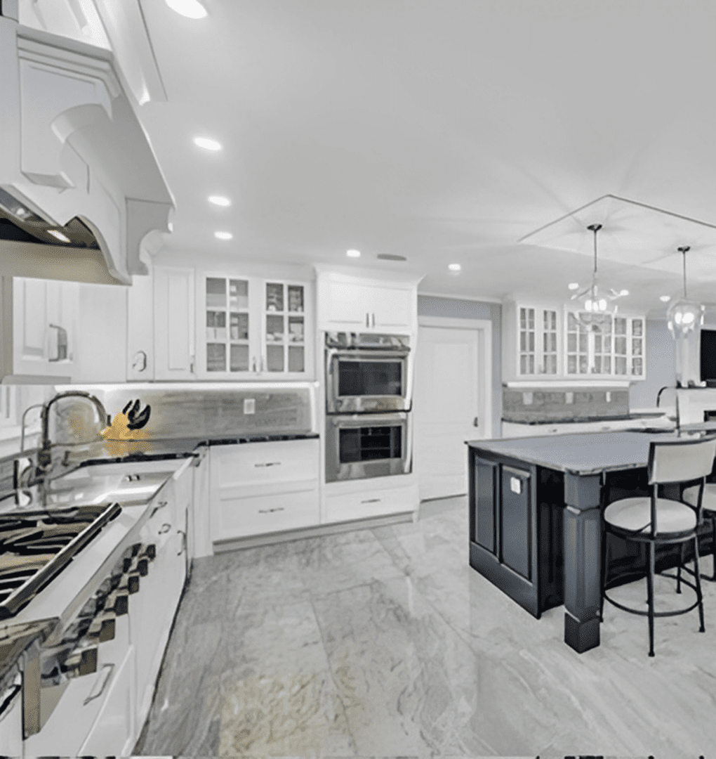 Modern kitchen with white cabinets and a central island with bar stools.