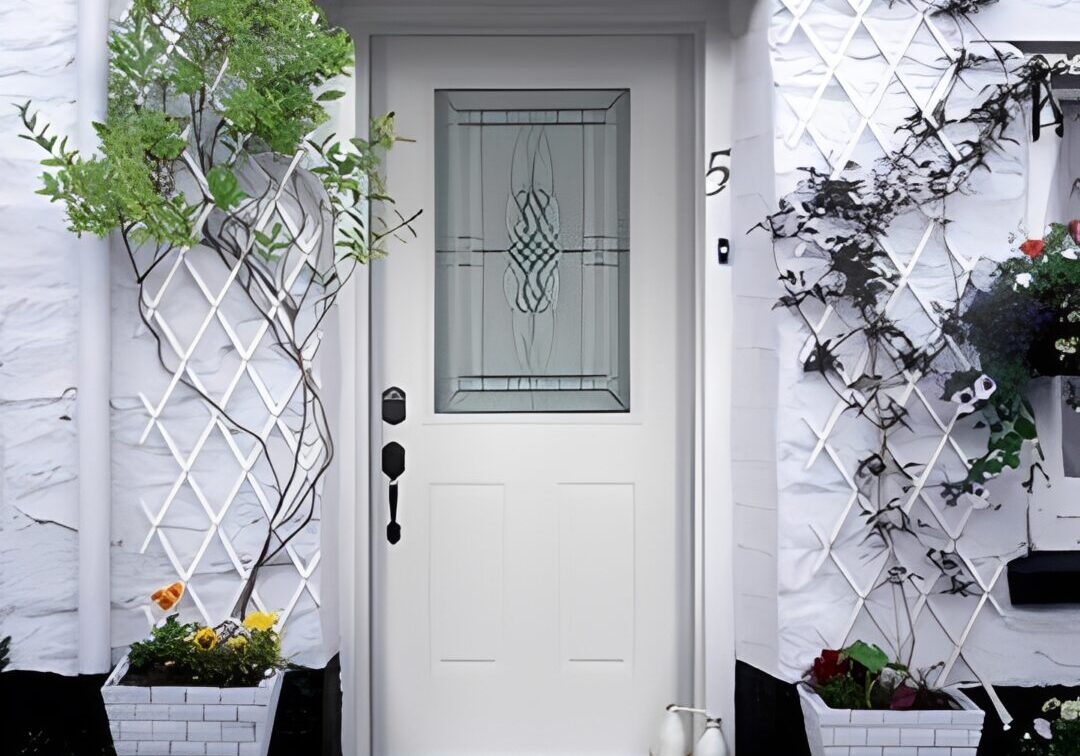 A white front door with decorative glass and potted plants on either side.