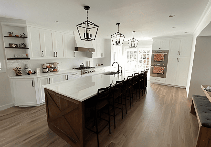 Modern kitchen with white cabinets, dark island, and hanging lantern lights.