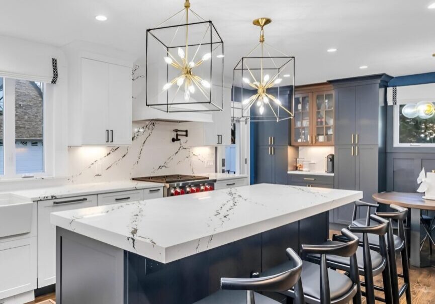 Modern kitchen with marble island and stylish pendant lights.